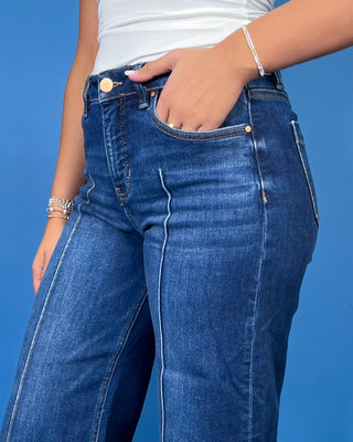 Dark wash high-rise cropped wide leg jeans with statement front seam detailing, subtle fading, and a wide cuffed hem.