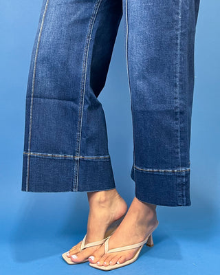 Dark wash high-rise cropped wide leg jeans with statement front seam detailing, subtle fading, and a wide cuffed hem.