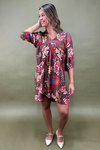 Person wearing a colorful butterfly pattern dress against a green background