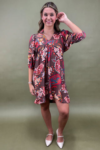 Person wearing a colorful butterfly pattern dress against a green background
