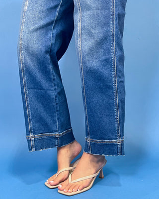 Dark wash high-rise cropped wide leg jeans with contrast front seam detailing, subtle fading, utility-inspired front pockets, and a wide cuffed hem.