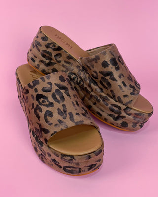 Leopard print platform sandals on a pink background