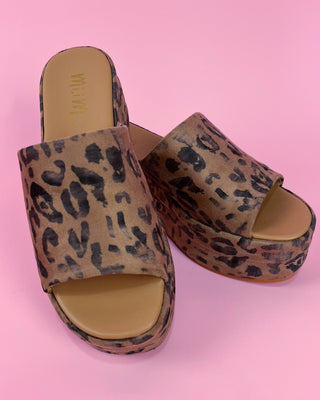 Leopard print platform sandals on a pink background