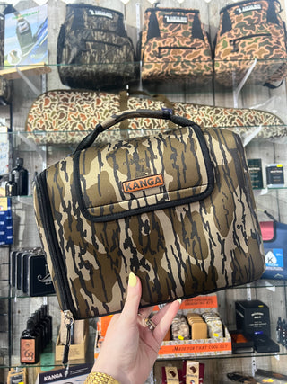 Camouflage lunch bag held by a hand with a store shelf in the background
