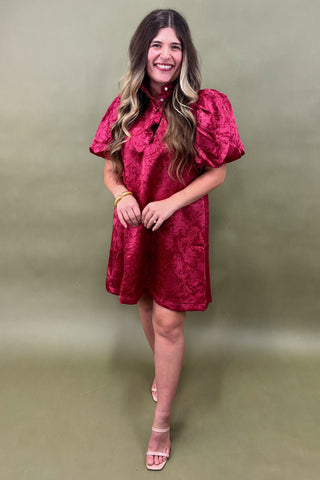 Woman wearing a red dress against a green background