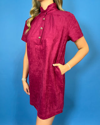Burgundy suede short sleeve shift dress with a mock neckline, decorative gold button details, and an easy relaxed silhouette.