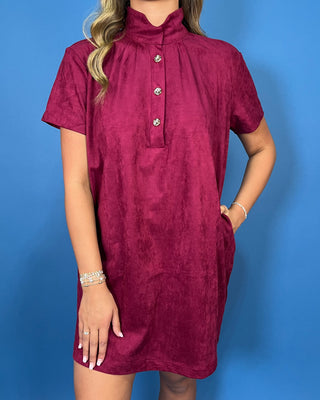 Burgundy suede short sleeve shift dress with a mock neckline, decorative gold button details, and an easy relaxed silhouette.