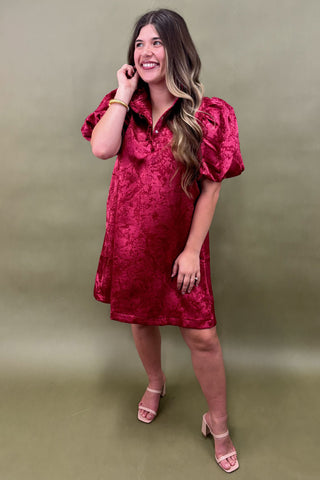 Woman wearing a red dress against a green background