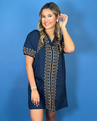 Navy short sleeve shift dress with statement puff sleeves, a flattering V-neckline, contrast tan loop trim detailing, and convenient side pockets.