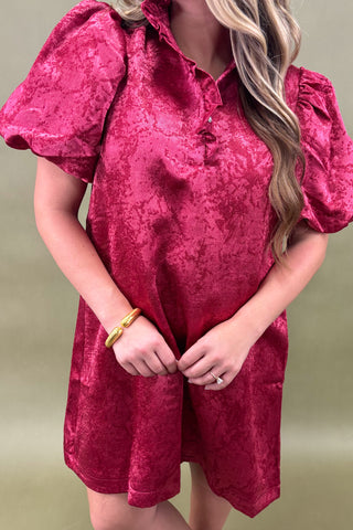 Woman wearing a pink textured dress against a beige background