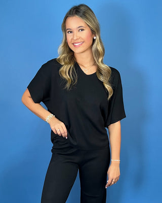 Black two-piece matching set featuring a relaxed V-neck short sleeve top and coordinating straight-leg pants for an effortless, comfortable everyday look.