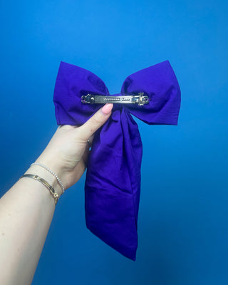 Purple LSU statement hair bow with hand-beaded gold and purple tiger paw prints, rhinestone accents, long tails, and a French barrette clip.