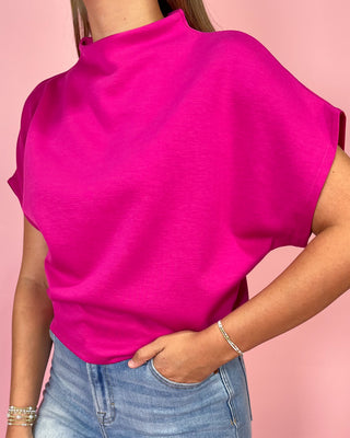 Person wearing a bright pink sleeveless top against a pink background