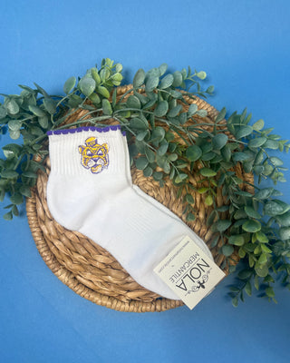 White LSU ankle socks with purple scalloped trim and an embroidered LSU Tiger logo, featuring a soft knit fabric and ribbed cuff for comfortable everyday wear.