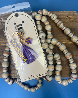 Purple and gold Louisiana gameday keychain featuring a Louisiana charm, faux leather tassel, paw print charm, checkered accent, gold-tone hardware, and lobster clasp.