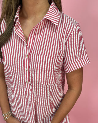 Red and white striped shirt worn by a person on a pink background