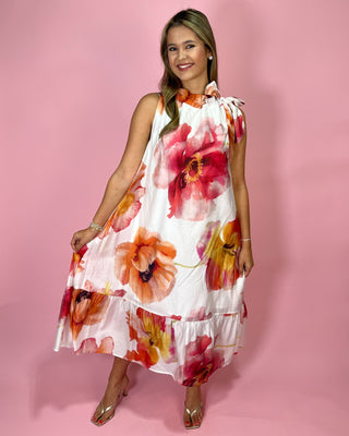 Woman wearing a floral dress against a pink background