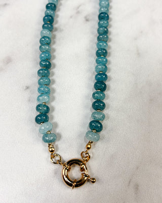 A beaded necklace featuring alternating light blue and teal-blue