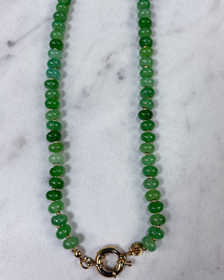 A green beaded necklace with polished round beads and a gold-tone toggle clasp