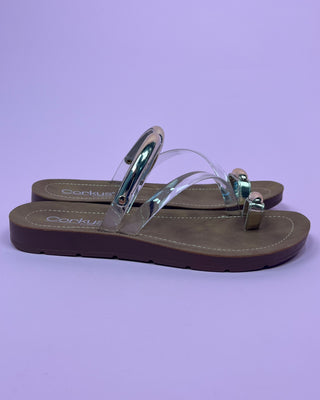 Clear sandal with brown soles on a purple background