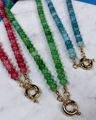 Three beaded necklaces with gold toggle clasp closures, featuring pink, green, and blue gradient bead strands