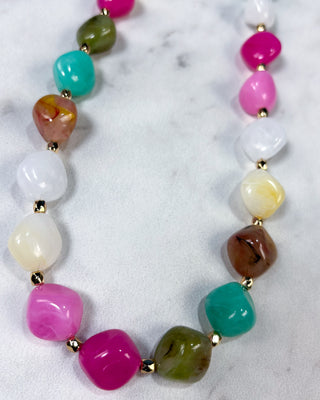 Multi-color chunky marbled plastic beaded necklace with gold-tone spacer beads and an adjustable chain for women.