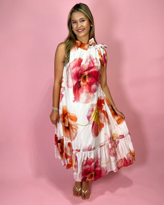 Woman wearing a floral dress against a pink background