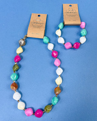 Multi-color chunky marbled plastic beaded necklace with gold-tone spacer beads and an adjustable chain for women.