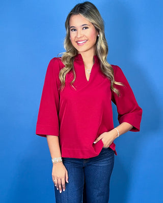 Red textured blouse featuring a split V-neckline with a structured collar, three-quarter bell sleeves, and an easy relaxed fit.
