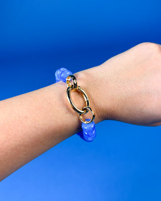 A gold link chain bracelet with translucent blue beads