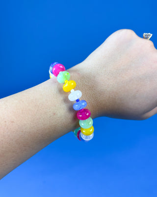 A multicolor beaded stretch bracelet worn on a person's wrist
