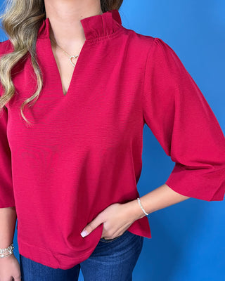Red textured blouse featuring a split V-neckline with a structured collar, three-quarter bell sleeves, and an easy relaxed fit.