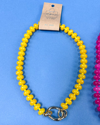 A yellow beaded stretch bracelet with a silver metal clasp