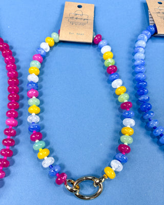A colorful beaded necklace with multicolor round beads and a gold clasp