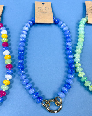 A beaded necklace with round blue beads and a gold clasp