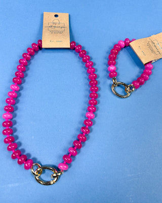 A pink beaded necklace and matching beaded bracelet with gold-tone clasp 