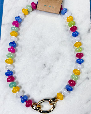 A colorful beaded necklace with alternating translucent blue, pink, yellow, mint green, and white beads
