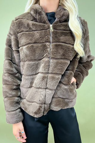 Brown faux fur jacket worn by a person against a green background