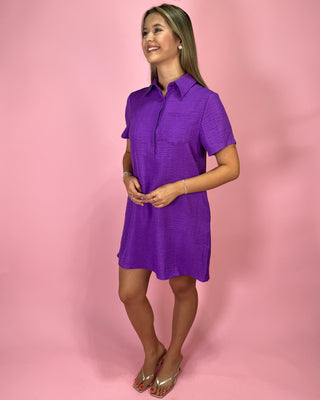 Woman wearing a purple dress against a pink background