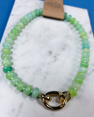A beaded stretch bracelet made of round light green and mint green gemstone beads