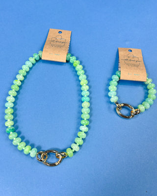 Two beaded bracelets in light green and aqua blue beads with gold-tone clasp closures