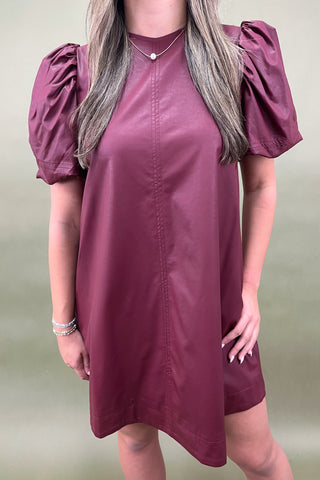 Maroon dress with puff sleeves worn by a person on a plain background