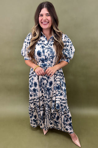 Woman wearing a blue floral dress against a green background