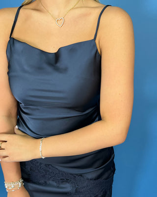 a navy satin slip dress with a sheer navy lace overlay at the hem asymmetrical 
