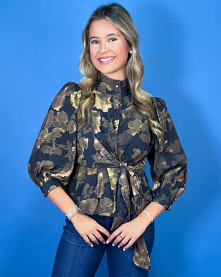 Black floral blouse featuring a high neckline, button-front detail, three-quarter puff sleeves, and a coordinating waist tie for a flattering finish.