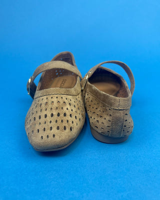 Brown Faux Suede Mary Jeane One Strap Mule held up against a solid blue background. 