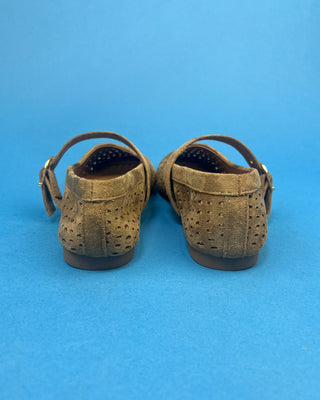 Brown Faux Suede Mary Jeane One Strap Mule held up against a solid blue background. 