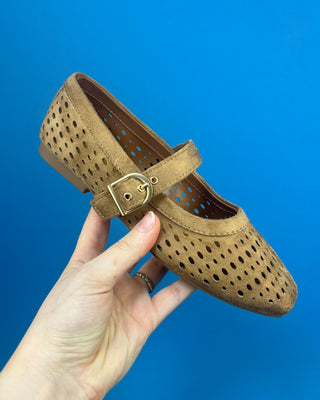 Brown Faux Suede Mary Jeane One Strap Mule held up against a solid blue background. 