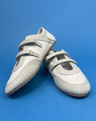 Ivory Faux Suede Mary Jane Double Strap Flat held up against a solid blue background. 