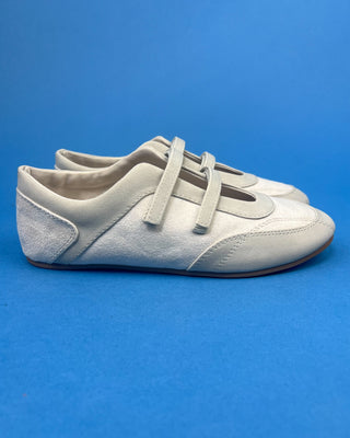 Ivory Faux Suede Mary Jane Double Strap Flat held up against a solid blue background. 